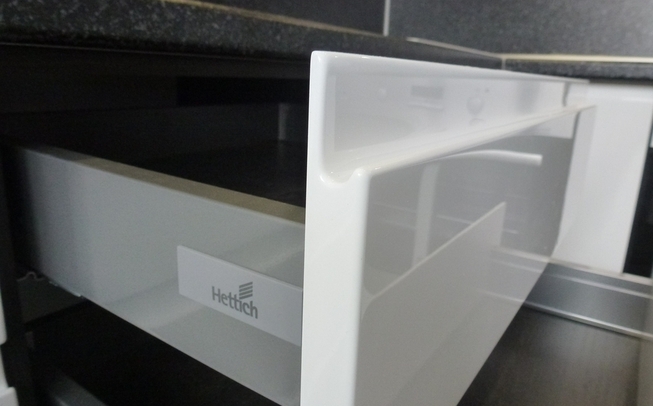 Белая кухня с черной столешницей угловой формы