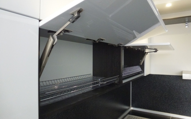 Белая кухня с черной столешницей угловой формы