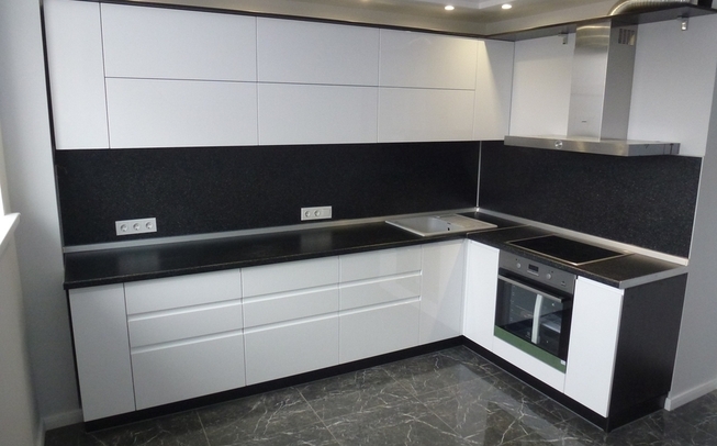 Белая кухня с черной столешницей угловой формы