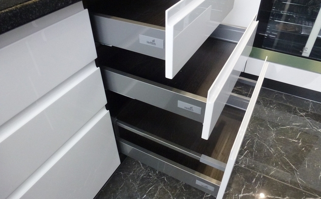 Белая кухня с черной столешницей угловой формы