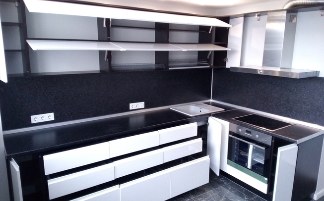 Белая кухня с черной столешницей угловой формы